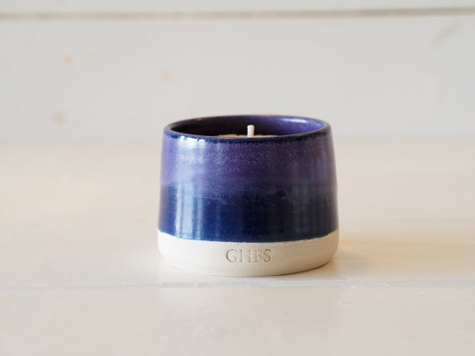 Lavender scented candle with lavender next to it
