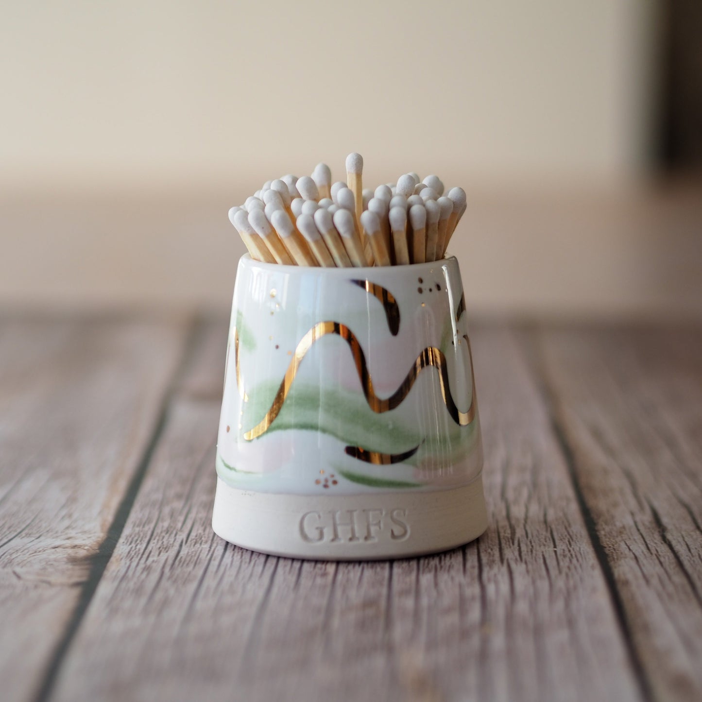 Ceramic match pot with green and gold ribbons